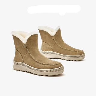 Bottes chaudes en daim et en cuir pour femme de couleur beige. Les bottes sont fourrées avec de la laine blanche.