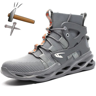 Botte de sécurité couleur grise. La botte est mise en scène avec un marteau et des clous sur la pointe.