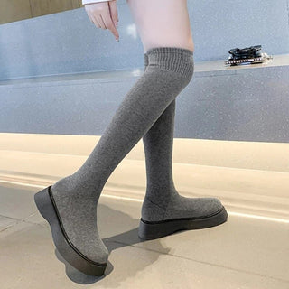 Jambes de femme, bottes chaussettes grises, semelles noires