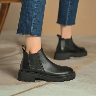 Bottes plates femme en simili cuir et fourrure porté par une personne que l'on ne voit pas