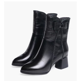 Bottes à talon mi-hautes avec un nœud sur le côté noires présentées sur fond blanc