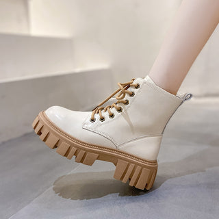 Bottes mi-hautes beige à plateforme épaisse marron. A lacets, un pied levé, talon au sol.