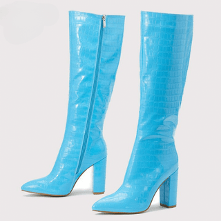 Paire de bottes hautes bleu clair, de trois-quarts vers la gauche. On voit la face interne avec la fermeture éclair de la botte en arrière-plan, et on voit la face externe de la botte en premier plan. Le tout sur fond blanc.